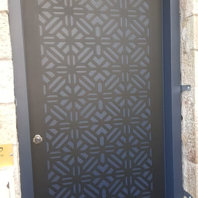 דלת מתכת עם דוגמה גיאומטרית ופלס עליון
