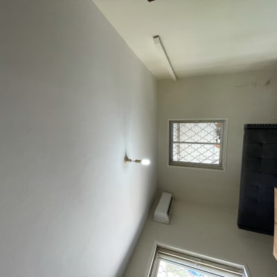 קיר צבוע בלבן עם מנורה תלויה