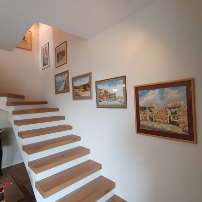 סולם מתקפל ליד גרם מדרגות עם תמונות על הקיר