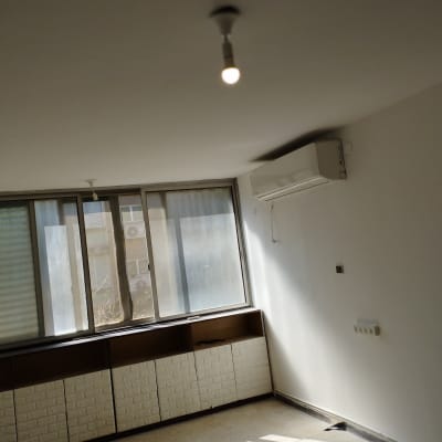 חדר ריק עם קירות לבנים ותאורה פשוטה