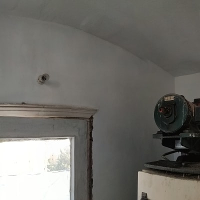 קיר צבוע בלבן עם מכונה גדולה בפינה