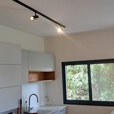 קיר צבוע בלבן עם תאורה עליונה