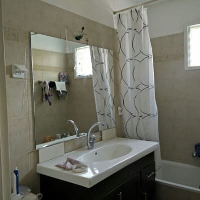 מראה גדולה מעל כיור בחדר אמבטיה