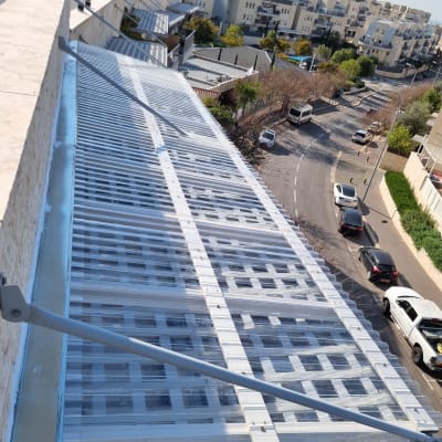 גג מתכת עם כיסוי שקוף מעל מבנה