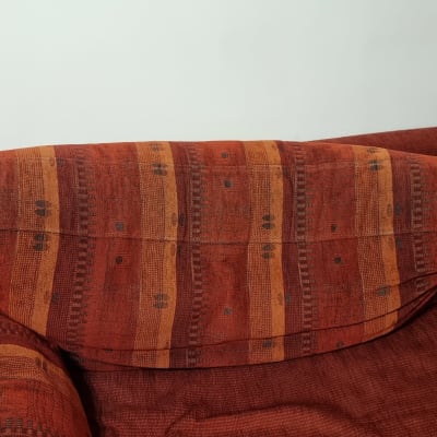 כרית כתומה עם דוגמה על ספה