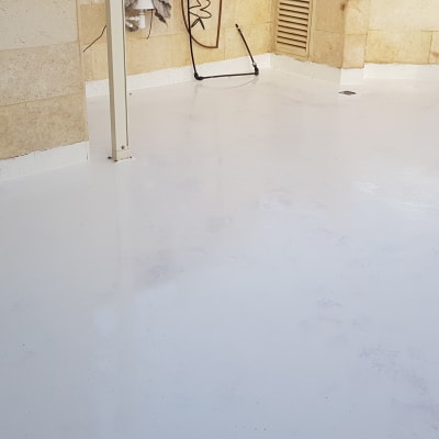 רצפה אטומה בלבן עם קירות אבן מסביב