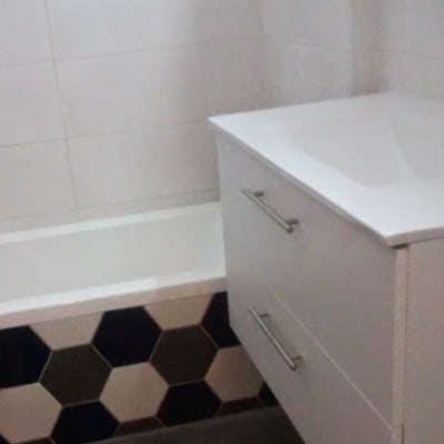 חדר אמבטיה עם אריחים משושים ושידה לבנה