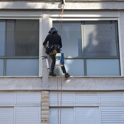 אדם בעבודות גובה עם ציוד בטיחות וחומרי בניין