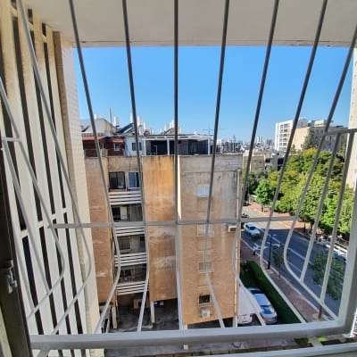 נוף עירוני מבעד לסורגים עם בניינים ורחוב