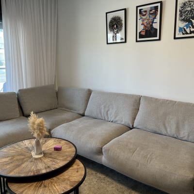 ספה אפורה עם כריות גדולות בחדר מגורים