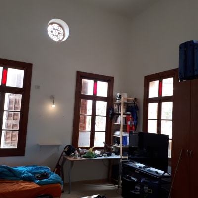 חדר עם חלונות, שולחן עבודה, מיטה וארון