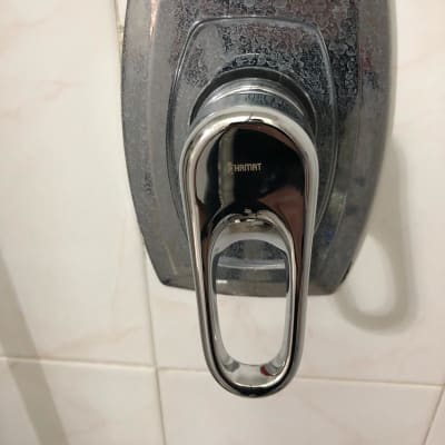 ברז כרום עם ידית מתכת על קיר קרמיקה