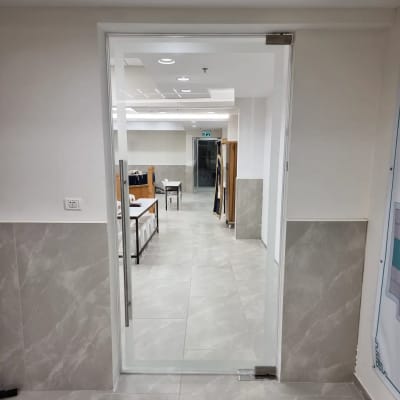 דלת זכוכית שקופה עם ידית מתכת בחדר פנימי