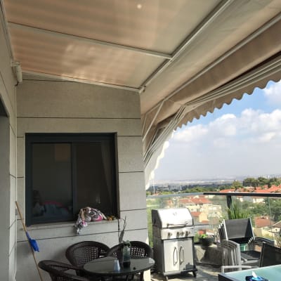 סוכך בד לבן עם מסגרת מתכת במרפסת