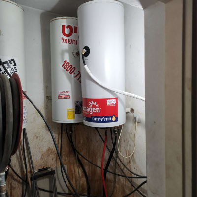 דוד שמש לבן עם צינורות מחוברים לקיר