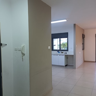 קיר צבוע חלקית, אריחי רצפה חדשים, חלון עם מסגרת שחורה