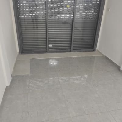 רצפת אריחים מול תריסים סגורים בחדר