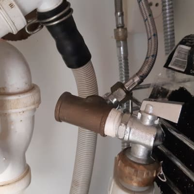 צינורות פלסטיק וברז מתכת מתחת לכיור