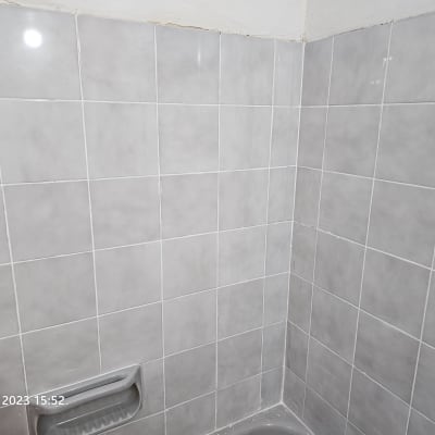 קיר אריחים עם ידית אחיזה במקלחת