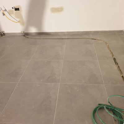 צינור ירוק על רצפה עם חוטי חשמל בקיר