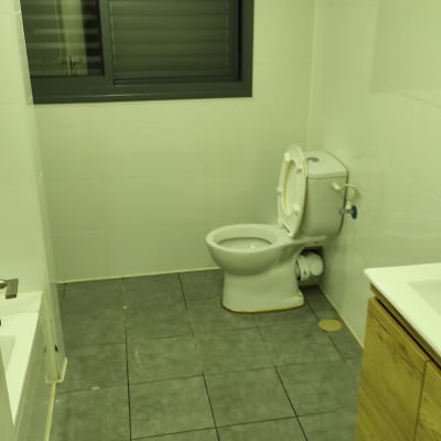 שירותים נקיים עם רצפה אריחים וקירות לבנים