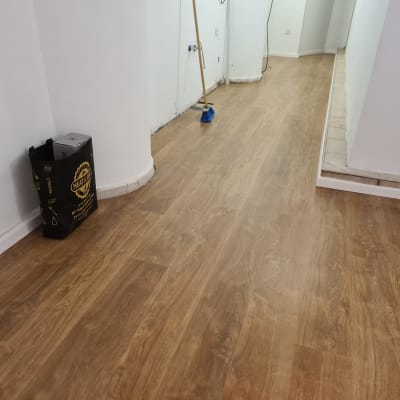 רצפת פרקט עץ חום במסדרון עם מטאטא