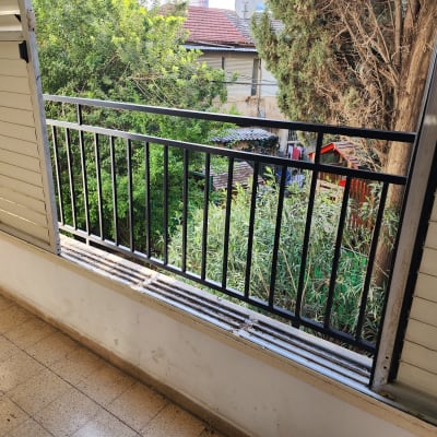 מעקה מתכת שחור עם תריסים פתוחים