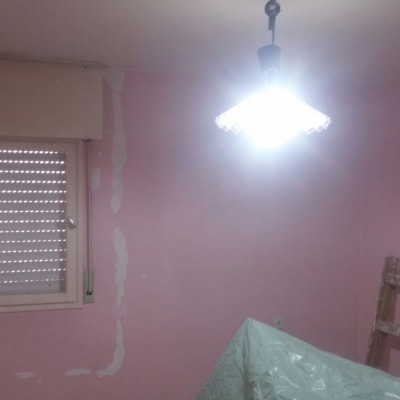 קיר ורוד עם תיקוני צבע וסולם עץ