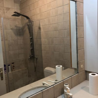 מקלחת עם ראש גשם ומדף עם מוצרי טיפוח