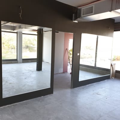 שתי מראות גדולות על קיר כהה בחדר ריק