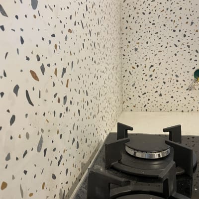 כיריים שחורים על רקע קיר עם חיפוי טרצו