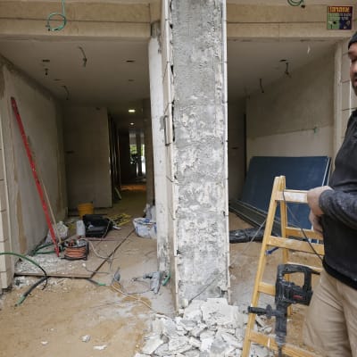 שיפוץ עם עמוד בטון, סולם, מקדחה ופסולת בנייה