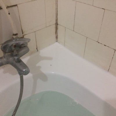 ברז אמבטיה עם אריחים לבנים וקיר רטוב