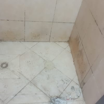 רצפת מקלחת עם אריחים מלוכלכים וניקוז