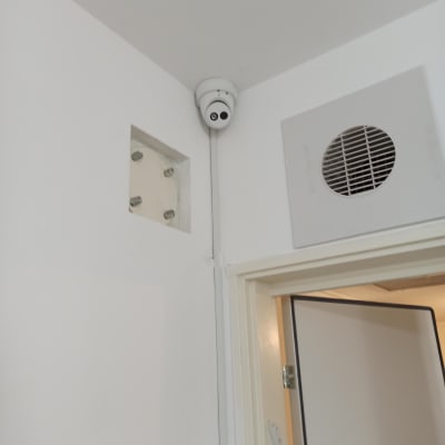 מצלמת אבטחה מותקנת בפינת תקרה לבנה