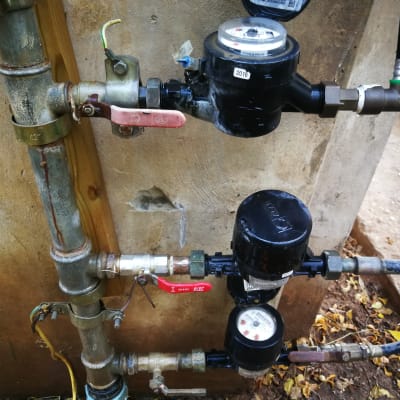 מד מים וצינורות מתכת עם ברזים