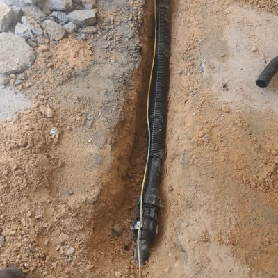 צינור פלסטיק שחור בתעלה באדמה