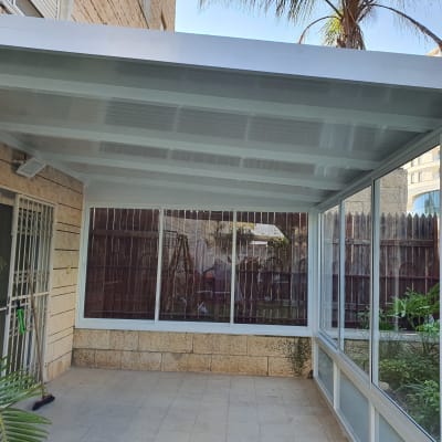 פרגולה מאלומיניום עם קירות זכוכית בחצר