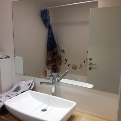 מראה גדולה מעל כיור בחדר אמבטיה