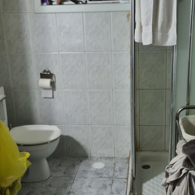 חדר אמבטיה עם מקלחת, שירותים וחלון