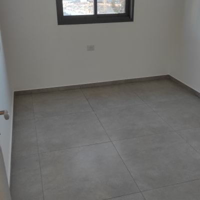 רצפה נקייה עם אריחים אפורים בחדר ריק