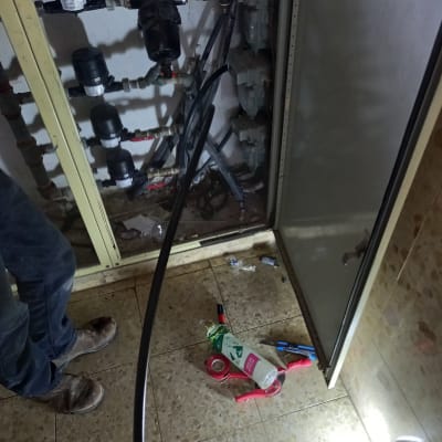 ארון צנרת עם כלים וחומרים על הרצפה