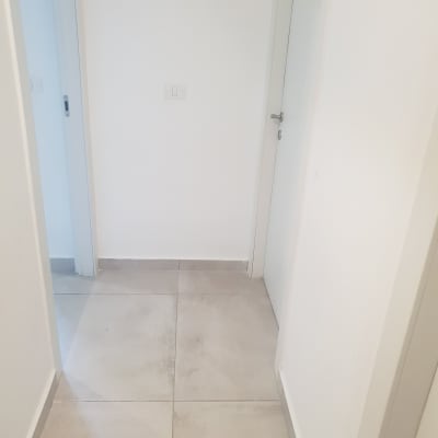 מסדרון עם קירות לבנים ודלתות לבנות