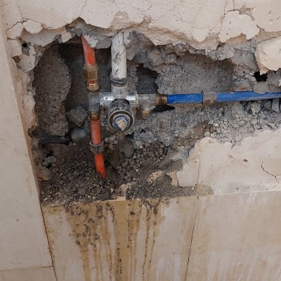 צנרת חשופה בקיר עם חיבורים ותיקונים