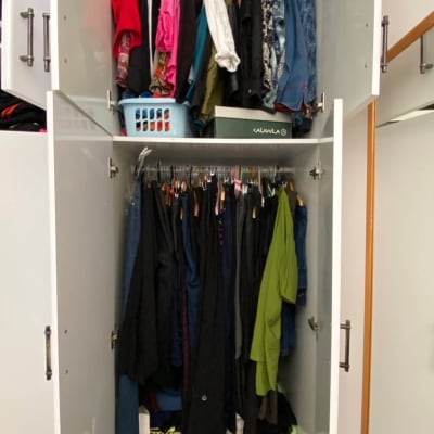 ארון בגדים עם בגדים תלויים וסל כביסה