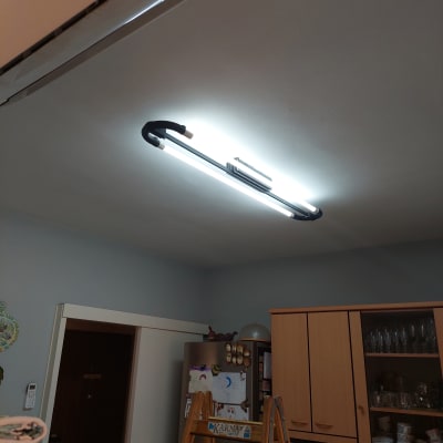 תאורת פלורסנט מותקנת על תקרה עם סולם עץ מתחתיה