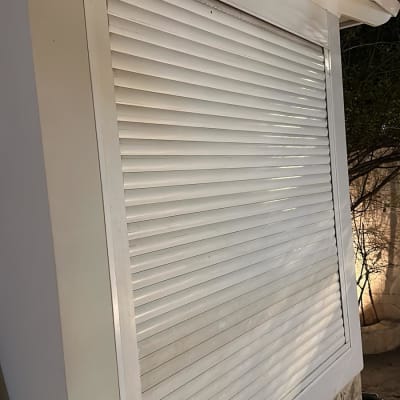 תריסים לבנים סגורים על קיר חיצוני