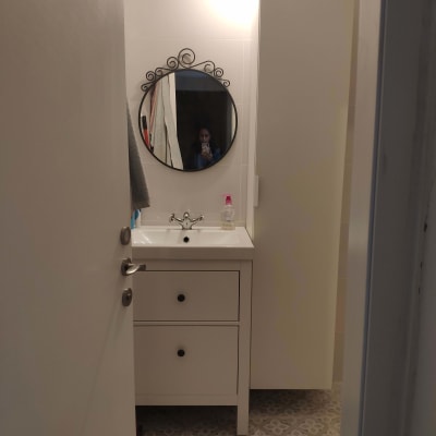 כיור אמבטיה עם ברז ומראה עגולה