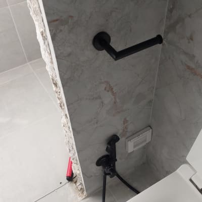 חלקי ברז מפורקים ליד אסלה בחדר אמבטיה