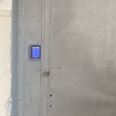 לוח מקשים כחול על דלת מתכת אפורה